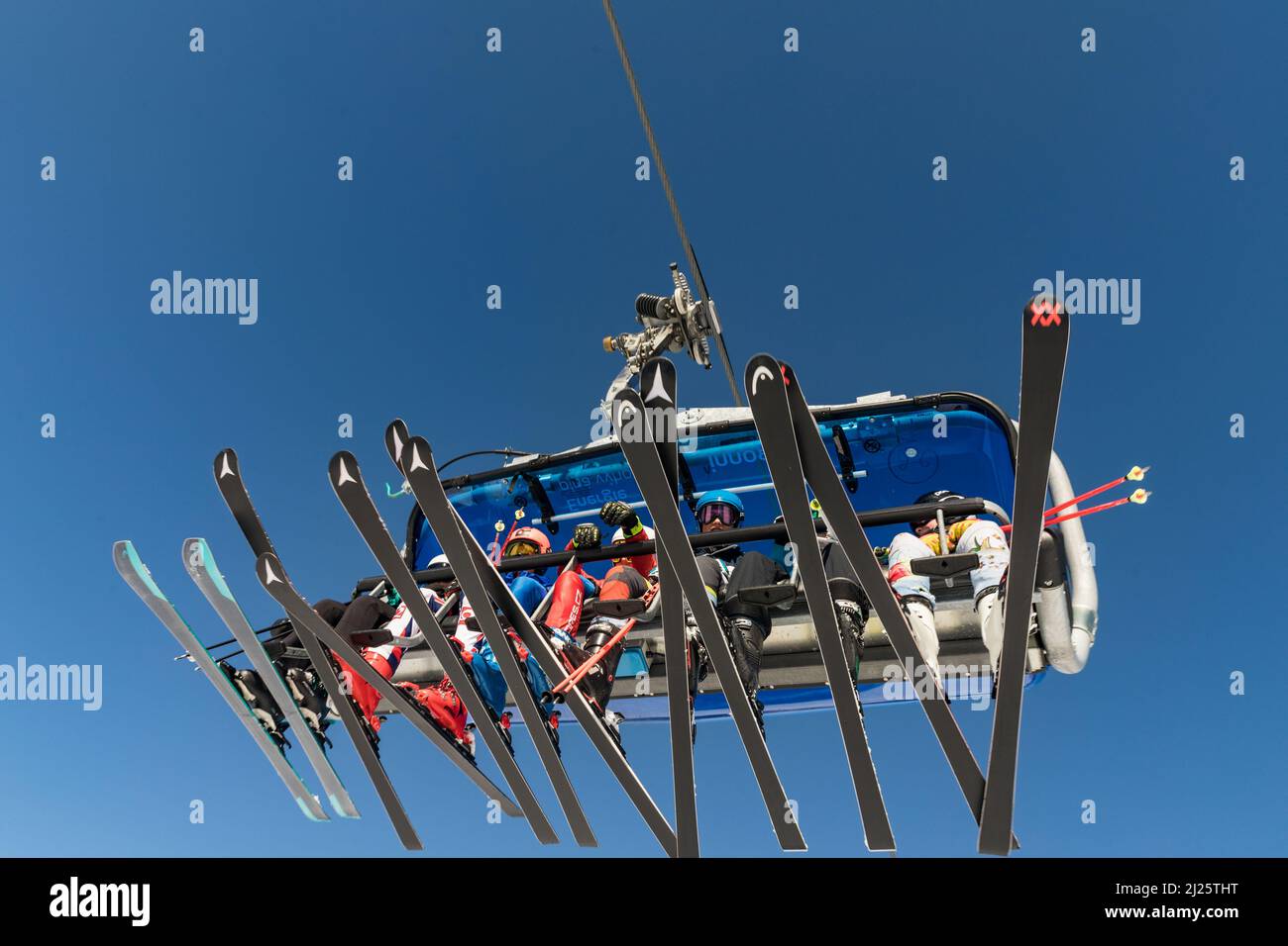 SPINDLERUV MLYN, REPÚBLICA CHECA - 10 DE MARZO. 2022: Vista de la telesilla, esquiadores y esquís en un día soleado, en el fondo el cielo azul turquesa. SPI Foto de stock