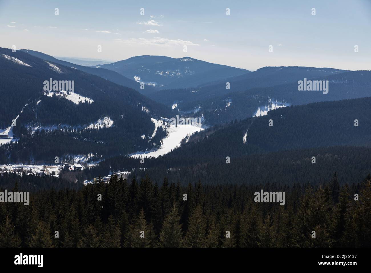 Vista de la estación de esquí Spindleruv Mlyn en la montaña Krkonose desde la cima de la colina Medvedin. Estación de esquí de invierno Spindleruv mlyn, pistas de avión y Hromovk Foto de stock