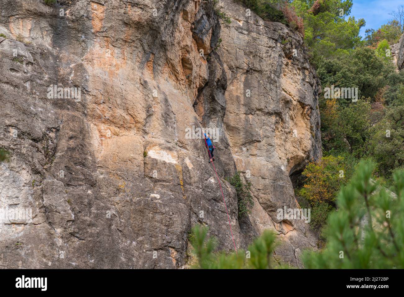 Una mujer, vista trasera, sube a una pared de roca en Siurana. Priorat, Cataluña, España. Foto de stock