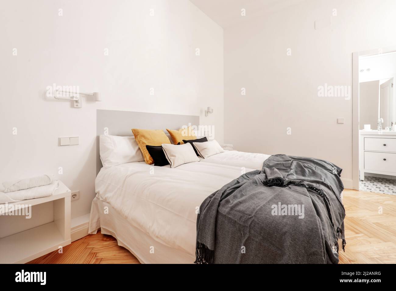 Cojines en blanco grande cama antigua con detalles tallados en dormitorio  con empapelado y mesillas de noche Fotografía de stock - Alamy