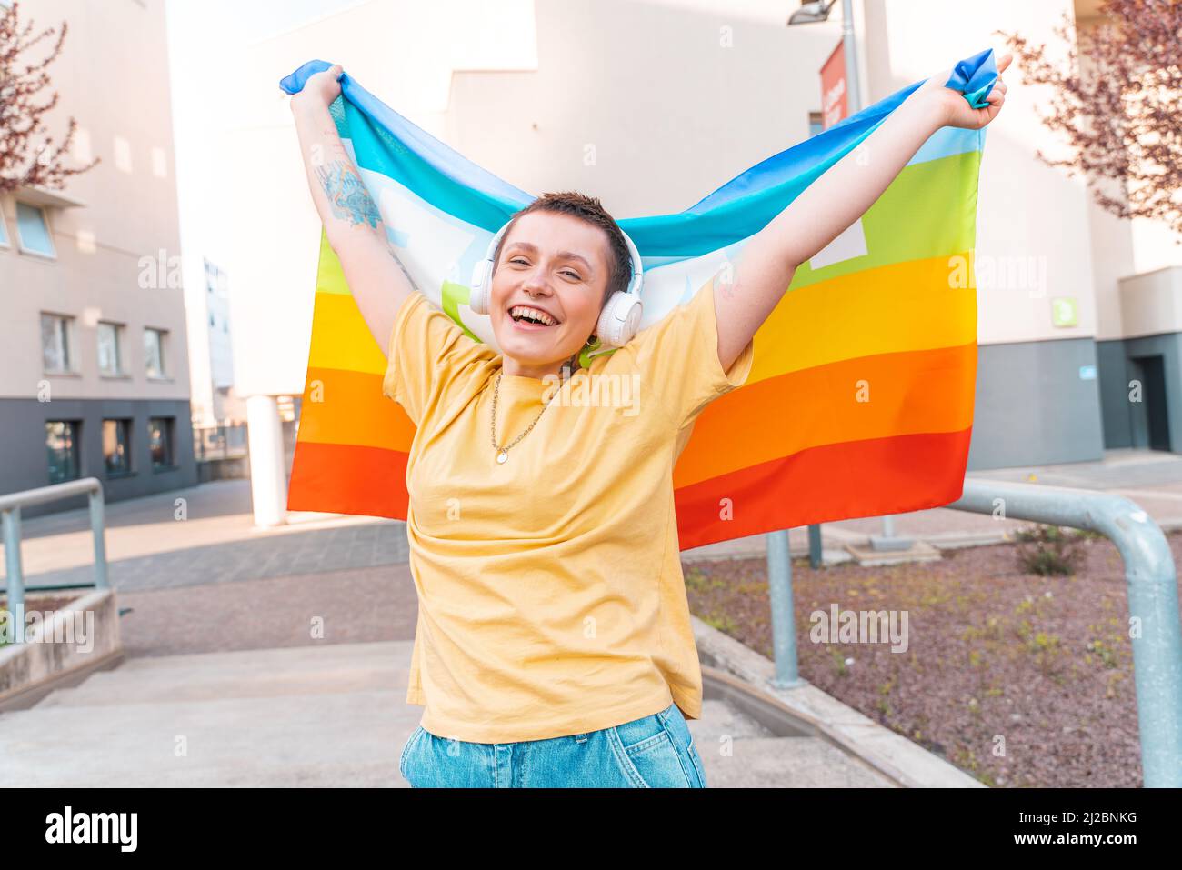 Una mujer feliz con la bandera de paz está en contra de la guerra y la discriminación Foto de stock