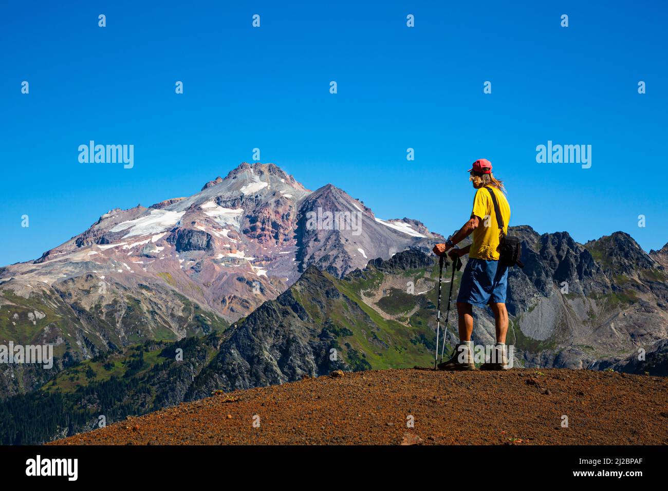 WA21238-00...WASHINGTON - Caminando viendo Glacier Peak desde la cresta del cono de Chuck Cinder en el área de la naturaleza de Glacier Peak. Foto de stock