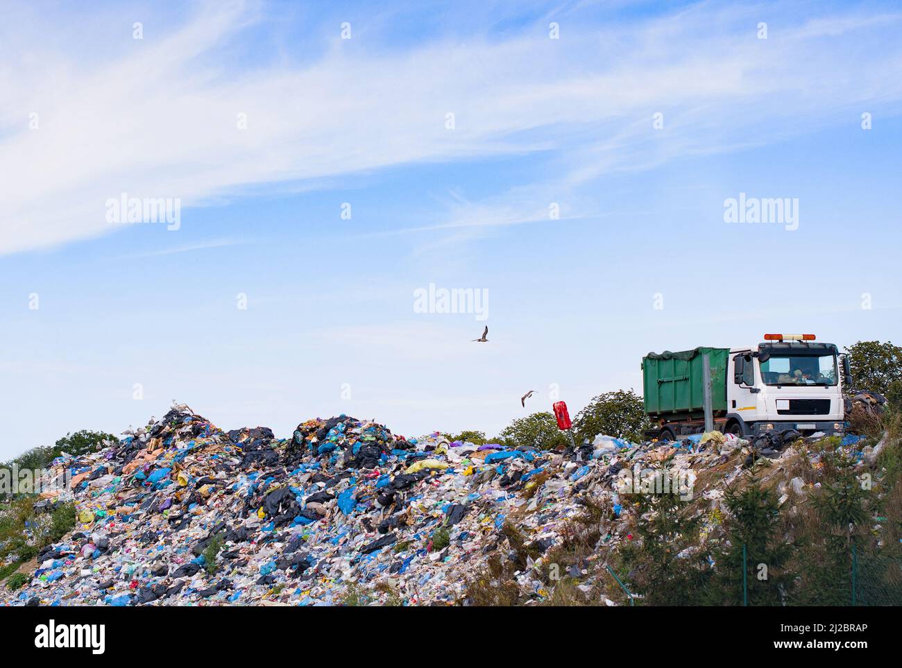 Eliminación de residuos en vertederos. El camión de basura descarga basura en el vertedero. Foto de stock