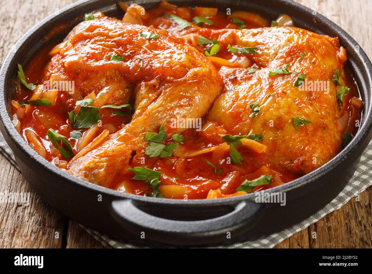 Pollo al horno con salsa de tomate de cebolla primer plano en una sartén  sobre la mesa. Horizontal Fotografía de stock - Alamy