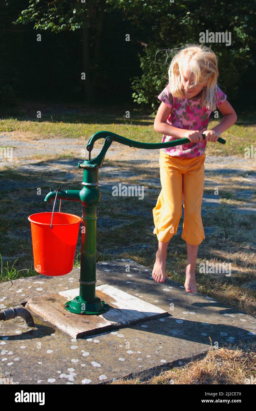 Flicka som pumpar upp vatten Foto de stock