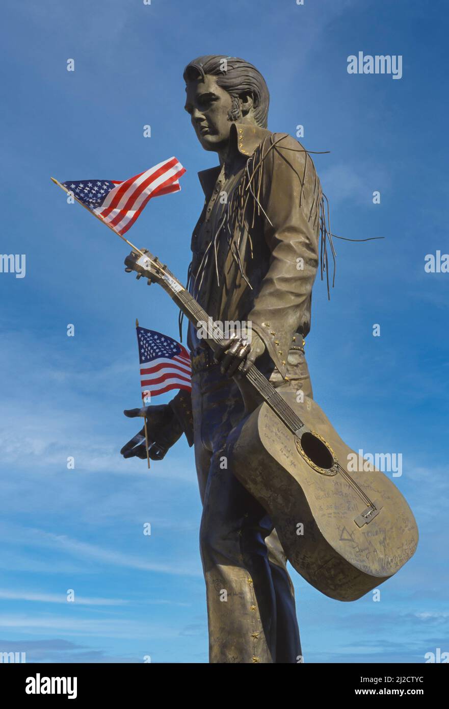 MEMPHIS, TENNESSEE, EE.UU. - Estatua del músico Elvis Presley, en la calle Beale, con banderas americanas. Foto de stock