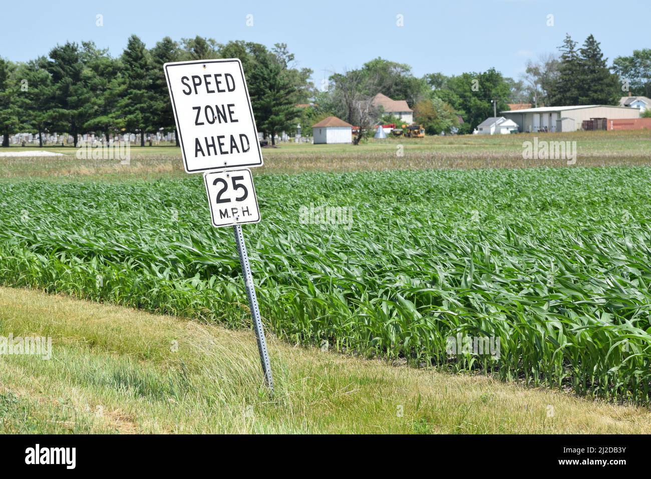 Señal de Speed Zone Ahead en la comunidad agrícola de Woodworth, Illinois; un campo de maíz en el fondo Foto de stock