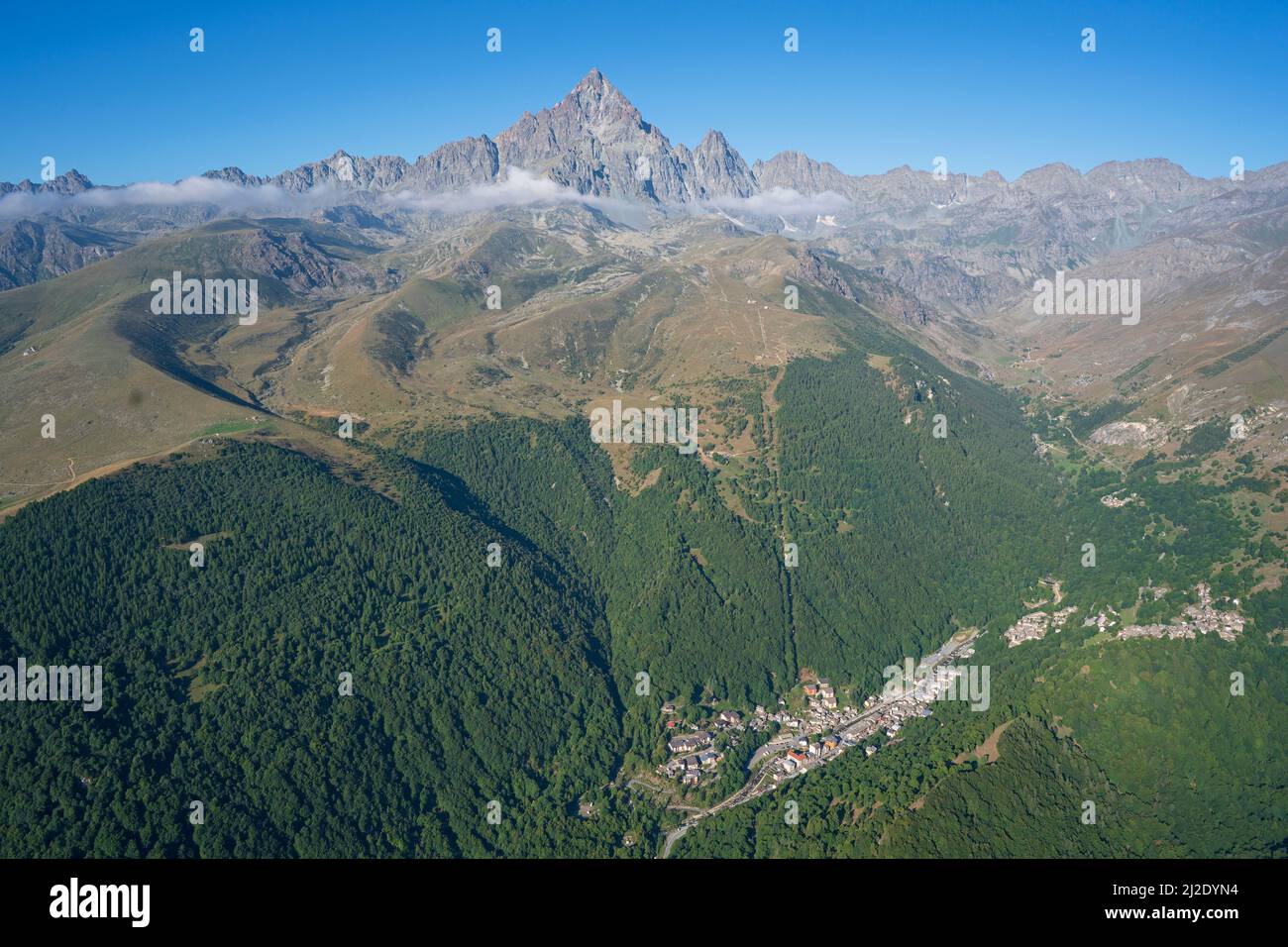 VISTA AÉREA. Monte Viso (3841m) visto desde el noreste con la ciudad de Crissolo en el Valle del Po. Provincia de Cuneo, Piamonte, Italia. Foto de stock