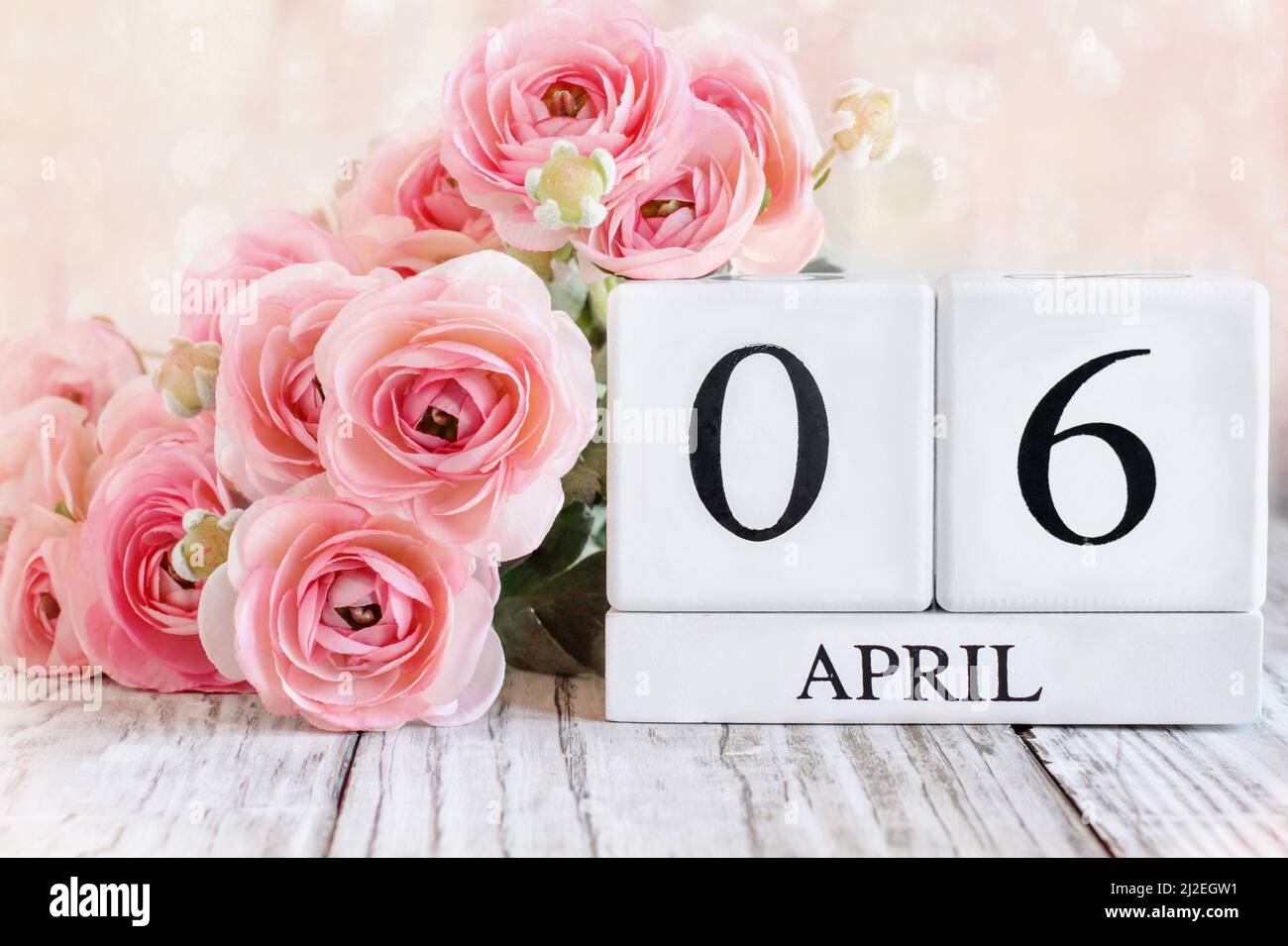 Bloques de calendario de madera blanca con fecha del 6th de abril. Enfoque selectivo con fondo borroso. Foto de stock
