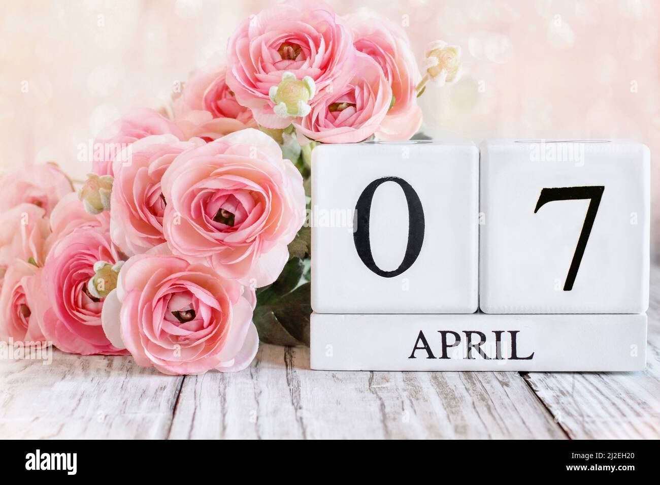 Bloques de calendario de madera blanca con fecha del 7th de abril. Enfoque selectivo con fondo borroso. Foto de stock