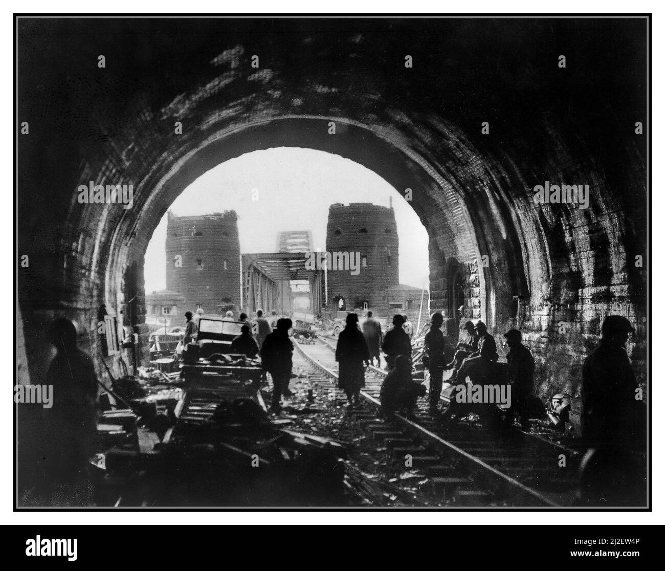 EL PUENTE EN REMAGEN Primera Ejército de EE.UU. Hombres y equipo de verter a través del puente Remagen; El puente Ludendorff en Remagen WW2 tropas de la División de Armorados de los EE.UU. 9th, Primer Ejército, avanzan a través del puente Ludendorff intacto a la orilla este del río Rin en Remagen, Alemania, dos jeeps derribados en primer plano. Alemania. Tomado el 11 de marzo de 1945 WW2 Segunda Guerra Mundial Foto de stock
