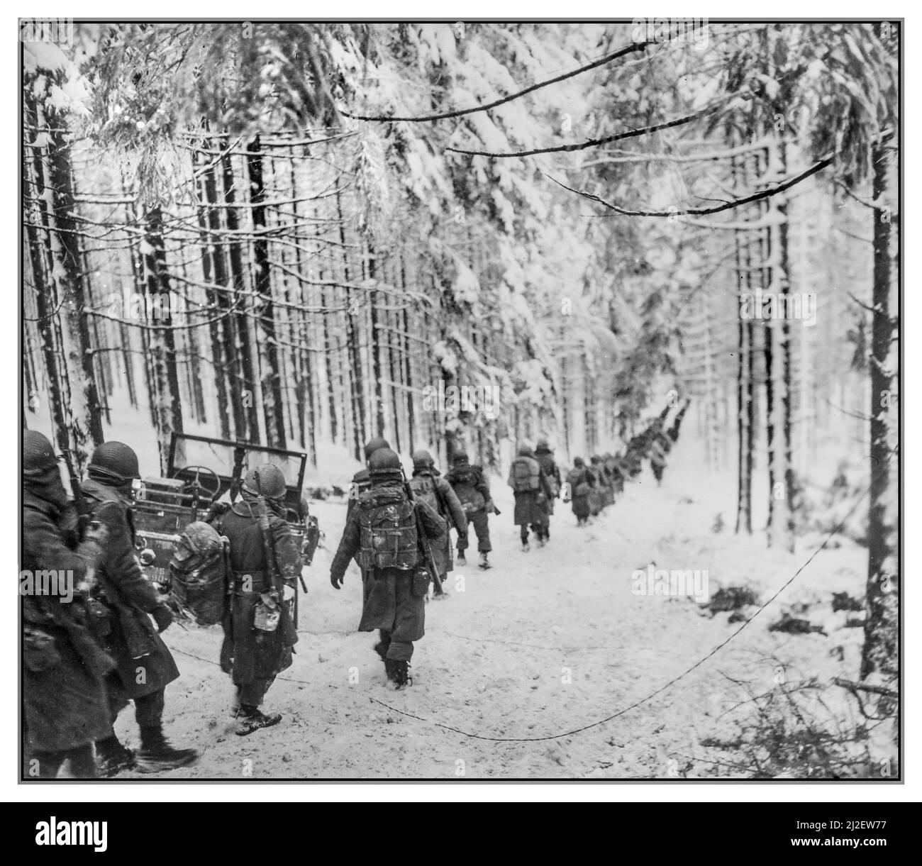 Batalla del Bulge WW2 Invierno Nieve Tropas de infantería estadounidenses Soldados del 289.º Regimiento de Infantería marchan a lo largo de la carretera cubierta de nieve de invierno en su camino para cortar la carretera Saint Vith-Houffalize en Bélgica. Departamento de Defensa. Departamento del Ejército. Oficina del Oficial Jefe de Señales. Soldados estadounidenses del Regimiento 289 de Infantería marchan a lo largo de la carretera cubierta de nieve en su camino para cortar la carretera Saint Vith-Houffalize en Bélgica. Fecha 24 de enero de 1945 Ellos avanzaban para bloquear la retirada del ejército nazi de la Alemania. Foto de stock