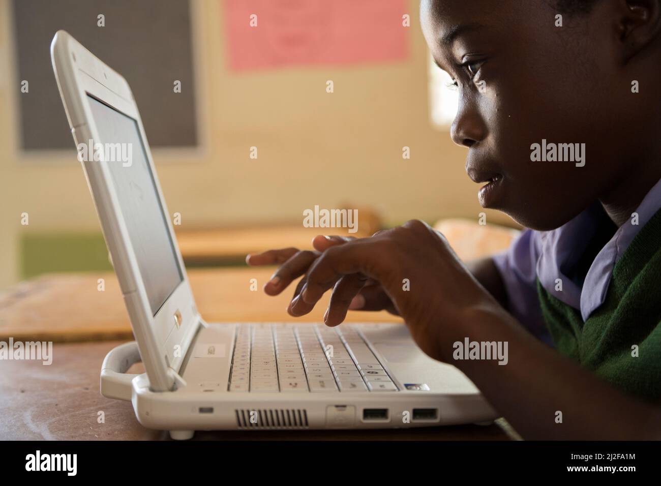 Evelyn Kaimbi (12 años), estudiante del grado 6, aprende usando una computadora portátil nueva en la Escuela Combinada Shikudule en la región de Oshana, Namibia. Como parte de la RE financiada por MCC Foto de stock
