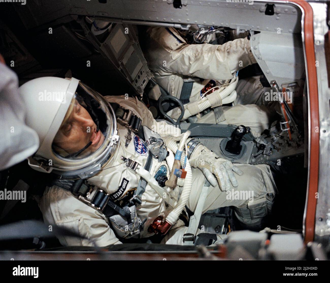 El astronauta Thomas Stafford, piloto, es visto en la nave espacial Gemini VI en la Sala Blanca sobre la Almohadilla 19 antes del cierre de las escotillas durante la cuenta regresiva previa al lanzamiento. En el fondo, parcialmente fuera de la vista, está el astronauta Walter 'Wally' Schirra, piloto de mando. Foto de stock