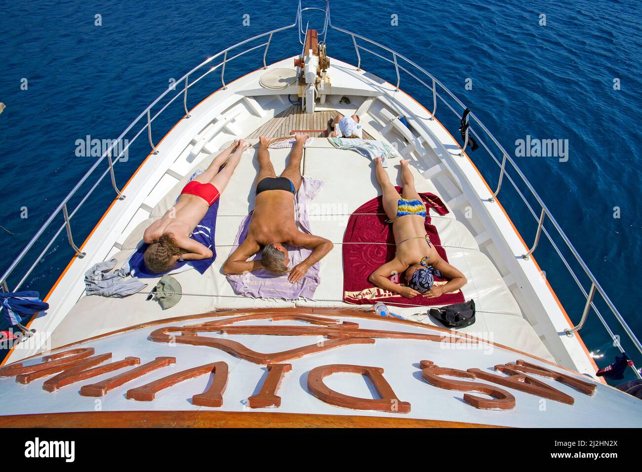 Tomar el sol en la terraza delantera, bote de buceo Kas, Kas, Lykia, Turquía Foto de stock