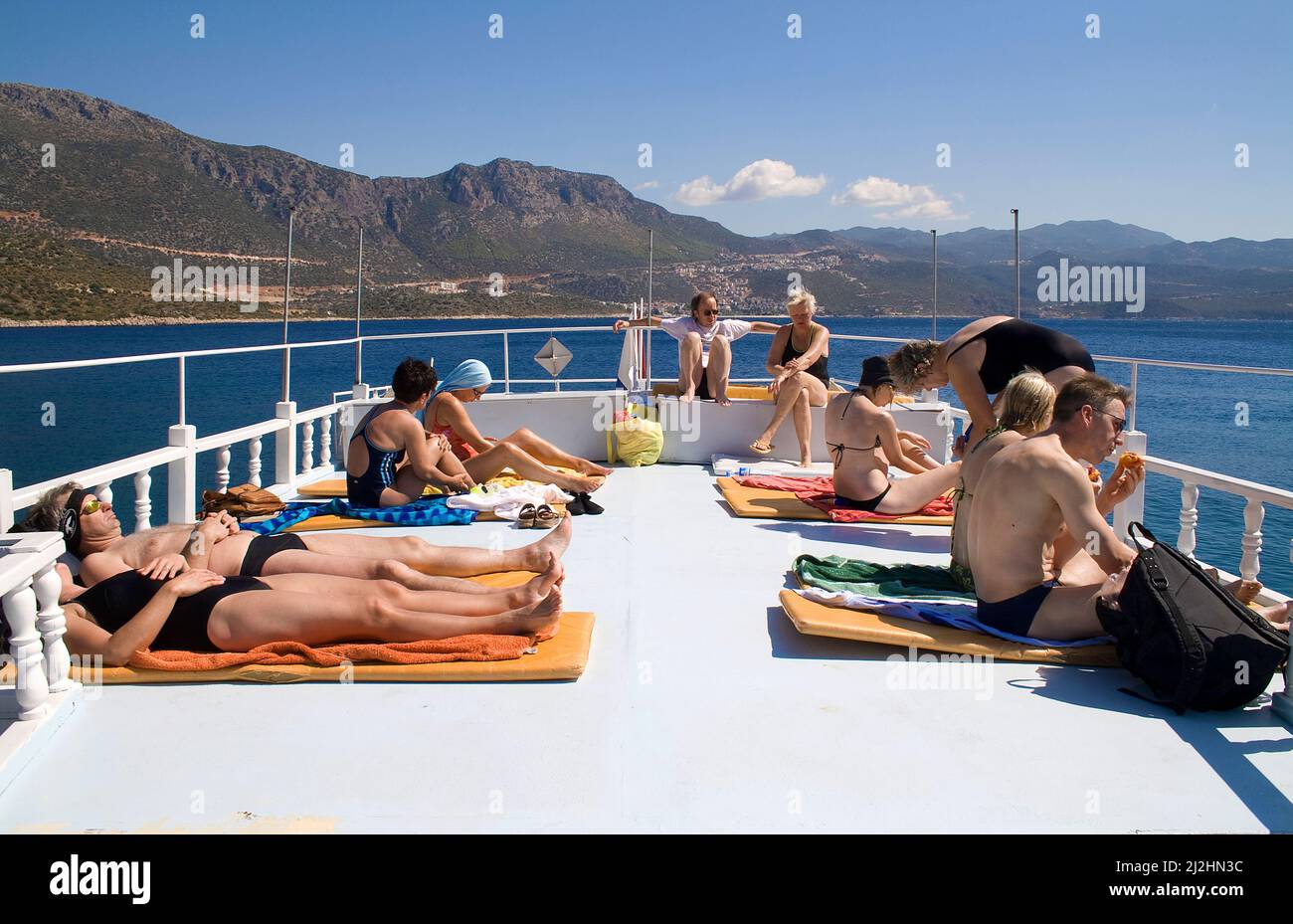 Tomar el sol en la terraza delantera, bote de buceo Kas, Kas, Lykia, Turquía Foto de stock