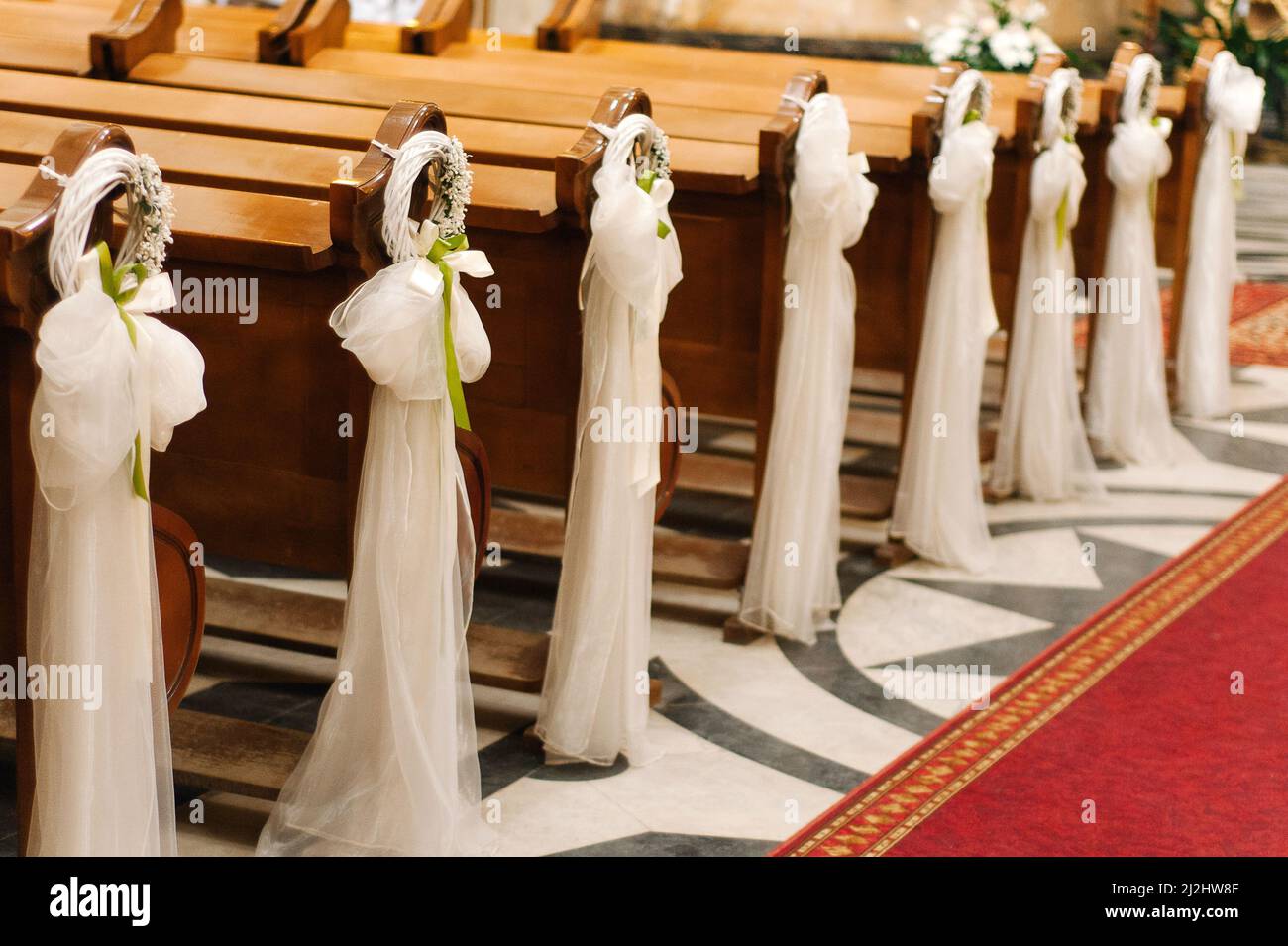 Bancos de madera decorados con flores tiernas y textiles blancos. Ceremonia  de boda iglesia decoración Fotografía de stock - Alamy