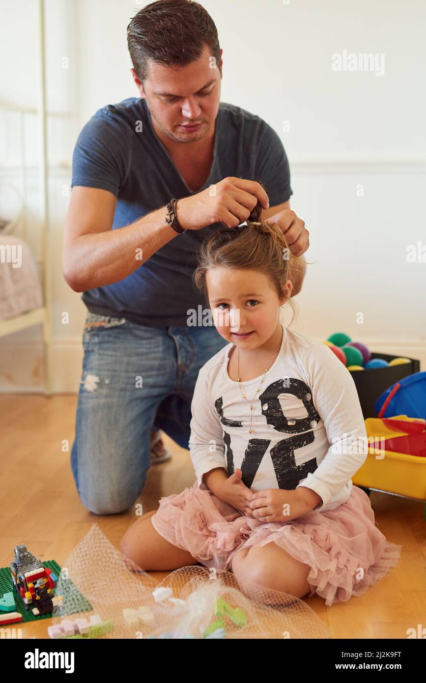 Papá hace los mejores peinados Foto de un padre peinando el cabello de sus hijas en casa Fotografía de stock Alamy