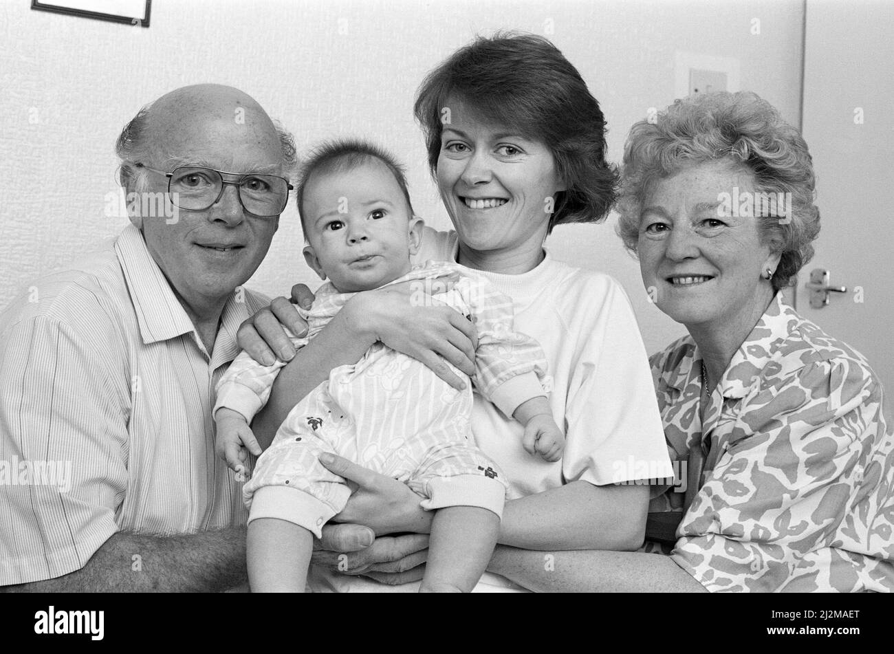 Hogar seguro... La Sra. Carolyn Brook cuddles bebé Alexander James, como abuelos James y Olive Brook les dan la bienvenida después de su vuelo de Irak. - Una mujer británica rehén con su marido y un hijo de cuatro meses y medio ha hablado por primera vez sobre cómo voló a casa desde Kuwait. Hablando desde la casa de su Crosland Moor, la Sra. Carolyn Brook, de 28 años, dijo hoy que su única preocupación ahora era por su marido Alan, de 34 años, que todavía se encuentra en la capital iraquí, Bagdad. 11th de septiembre de 1990. Foto de stock