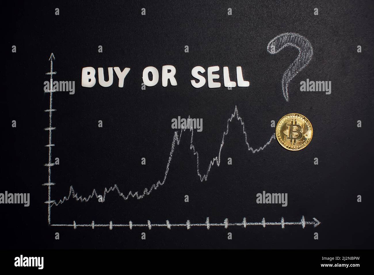 Gráfico Bitcoin con flecha hacia arriba y texto ' Comprar o vender' con signo de interrogación en pizarra como criptomoneda en línea valor de comercio concepto creciente. Foto de stock