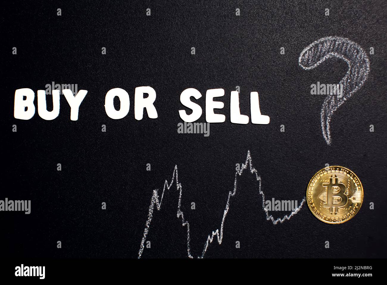 Gráfico Bitcoin con flecha hacia arriba y texto ' Comprar o vender' con signo de interrogación en pizarra como criptomoneda en línea valor de comercio concepto creciente. Foto de stock