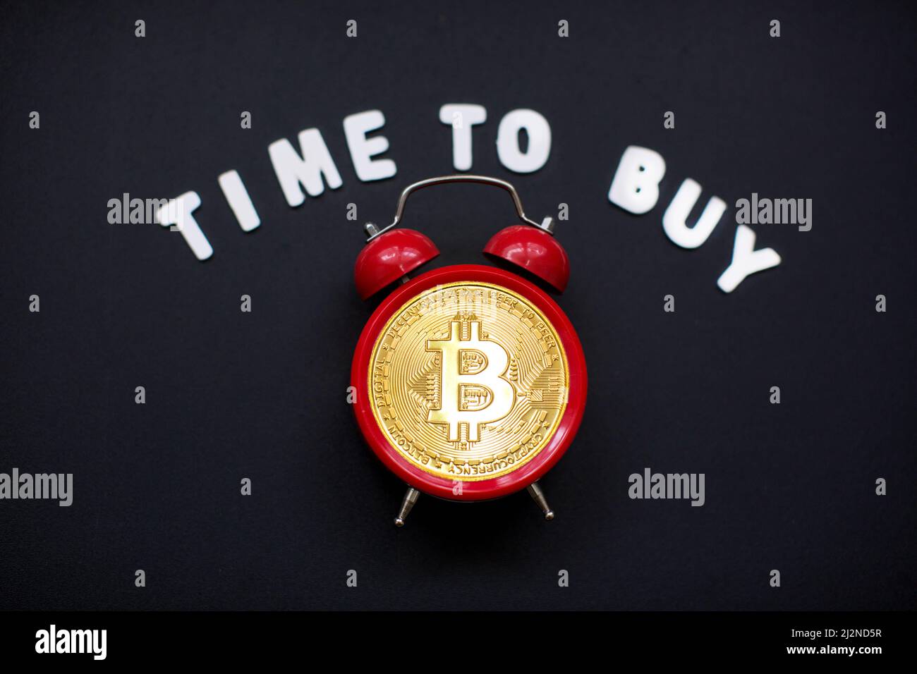 Bitcoin y reloj despertador y firmar 'hora de comprar'. Concepto de plazo para invertir en criptomoneda de bitcoin. Foto de stock