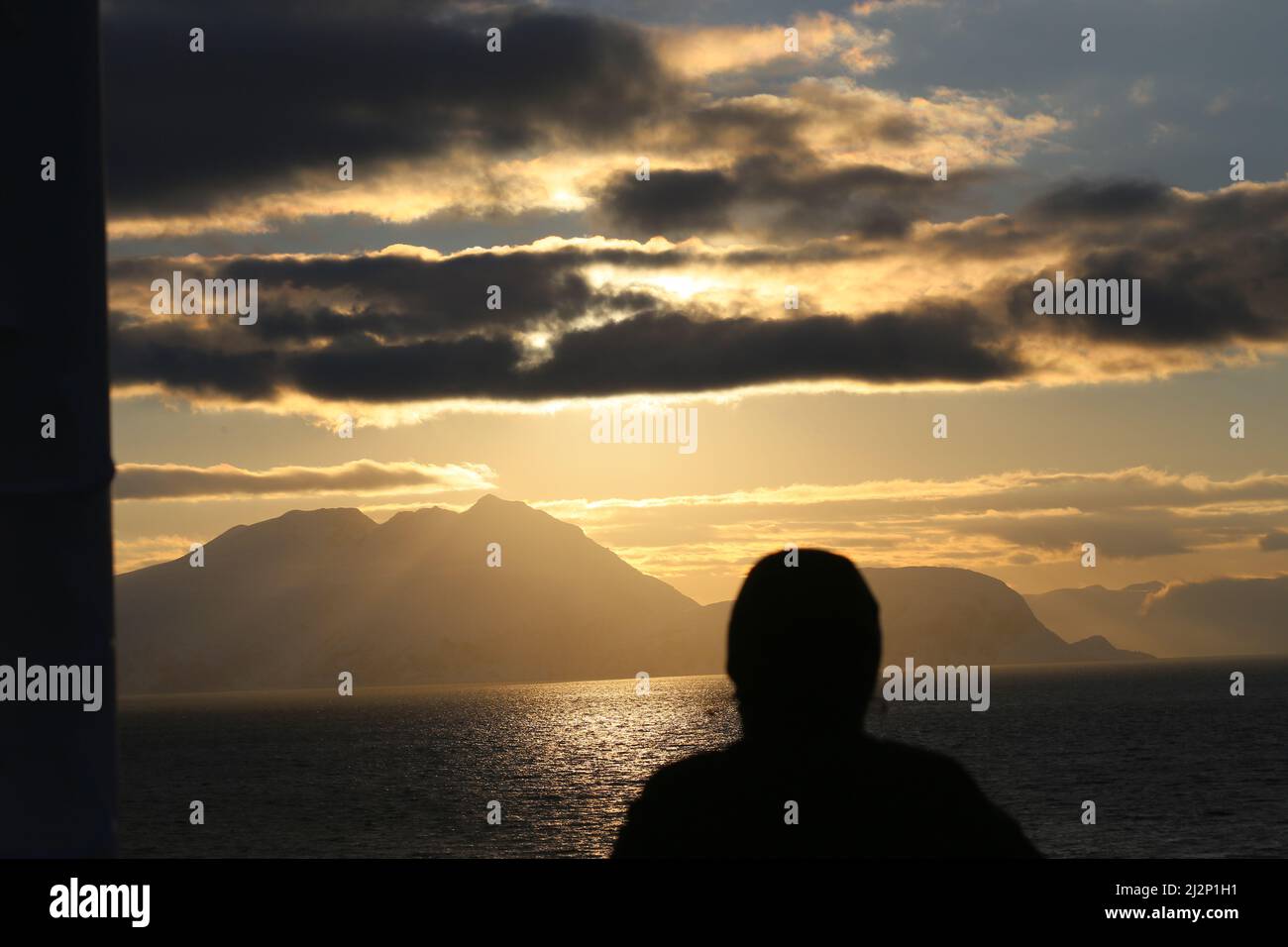 Von Alta nach Sortland - Die Insel Loppa in der Abendsonne Ein Passagier betrachtet die friedliche Situación Foto de stock