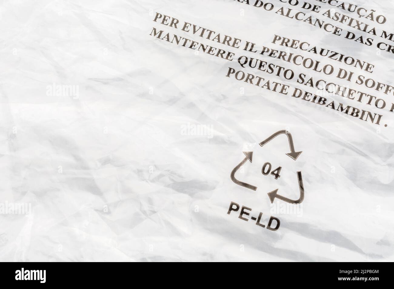 Peligro por asfixia (italiano) en bolsa de polietileno de baja densidad/LDPE. Para advertencia de seguridad infantil, símbolo Mobius de reciclaje de plástico. Foto de stock