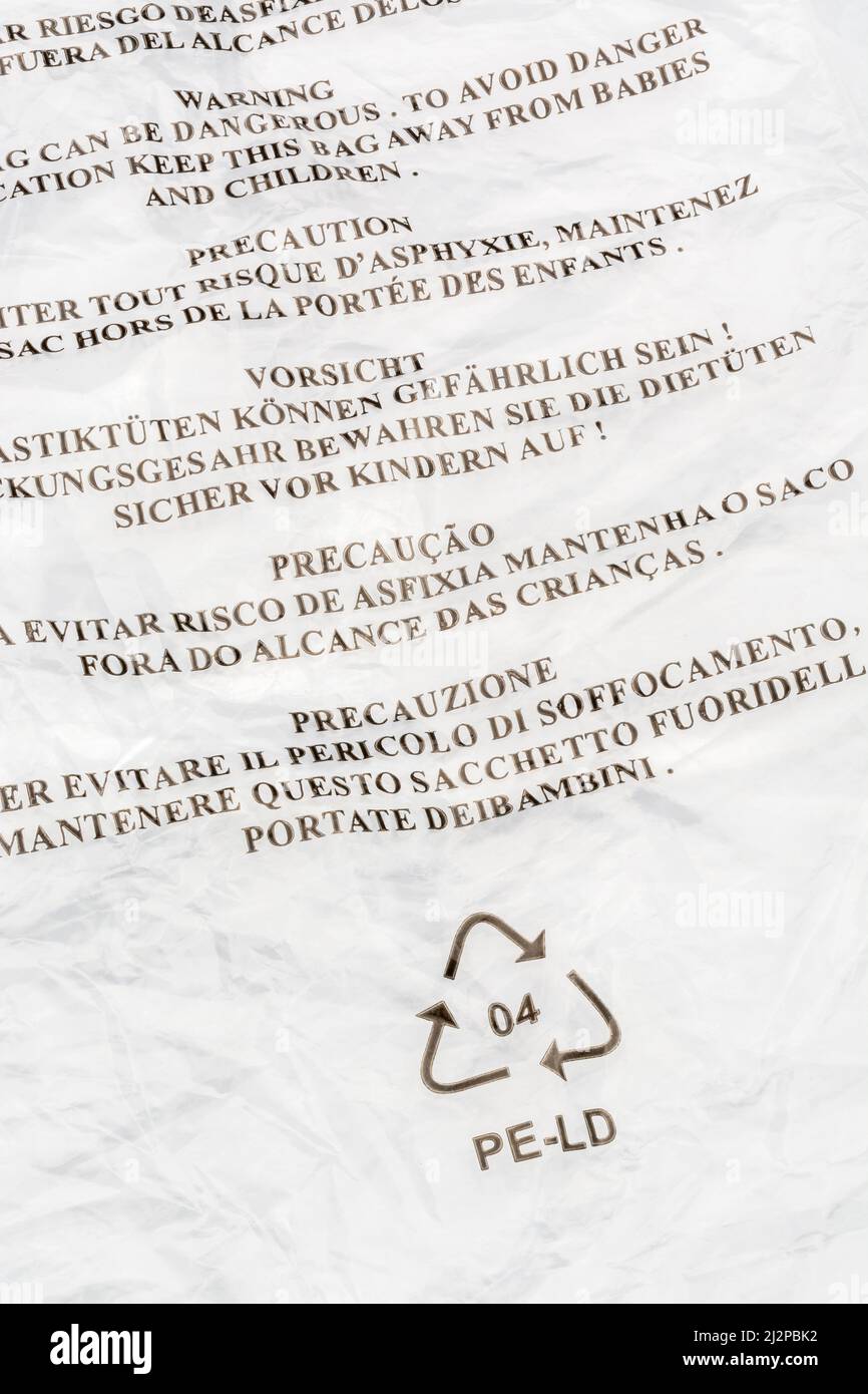 Peligro por aviso de asfixia (multilingüe) en bolsa de polietileno de baja densidad/LDPE. Para advertencia de seguridad infantil, símbolo Mobius de reciclaje de plástico. Foto de stock