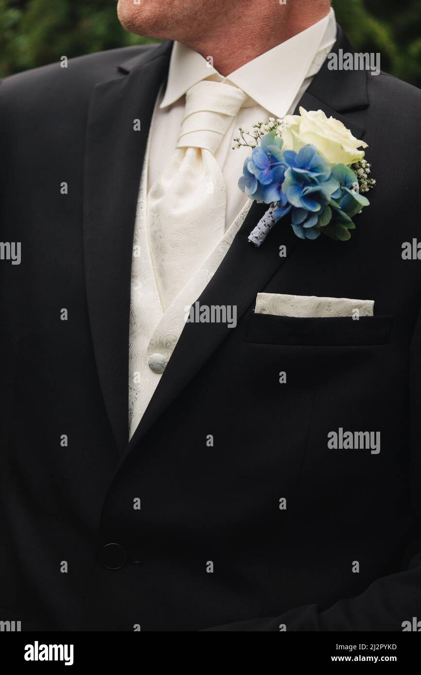 el en un traje negro de boda, un esmoquin en una camisa blanca, corbata y un abotón de rosas. Fotografías de alta calidad Fotografía de stock -