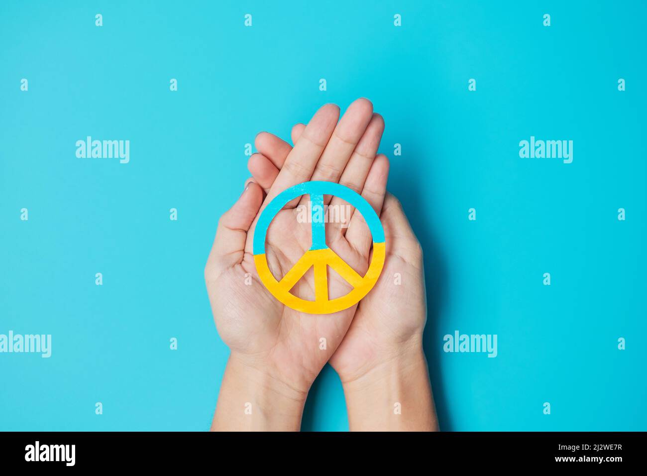 Apoyo a Ucrania en la guerra con Rusia, manos que sostienen el símbolo de la paz con la bandera de Ucrania. Oren, No hay guerra, detienen la guerra, están de pie con Ucrania y Nuclear Foto de stock