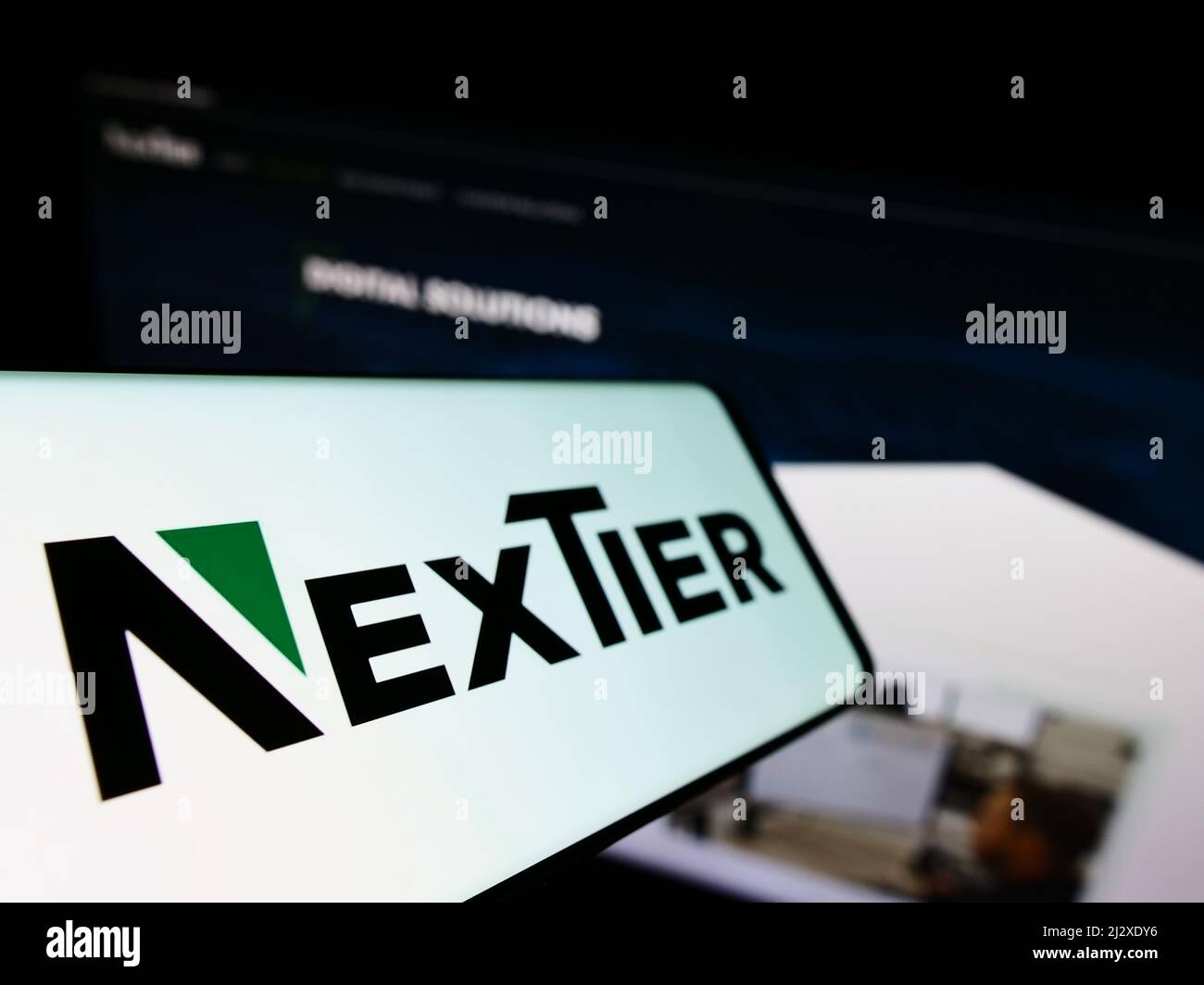 Smartphone con logotipo de la empresa estadounidense NexTier Oilfield Solutions Inc. En pantalla frente al sitio web de la empresa. Enfoque a la izquierda de la pantalla del teléfono. Foto de stock
