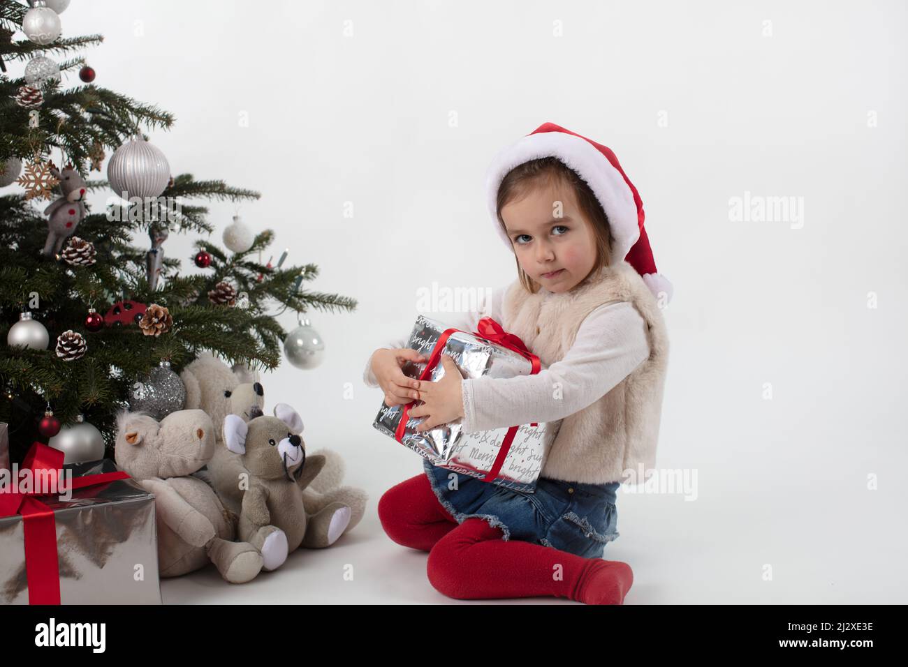 Niña de 3 años que sostiene su regalo de Navidad sin intención de  compartir. Emoción de niño inocente Fotografía de stock - Alamy
