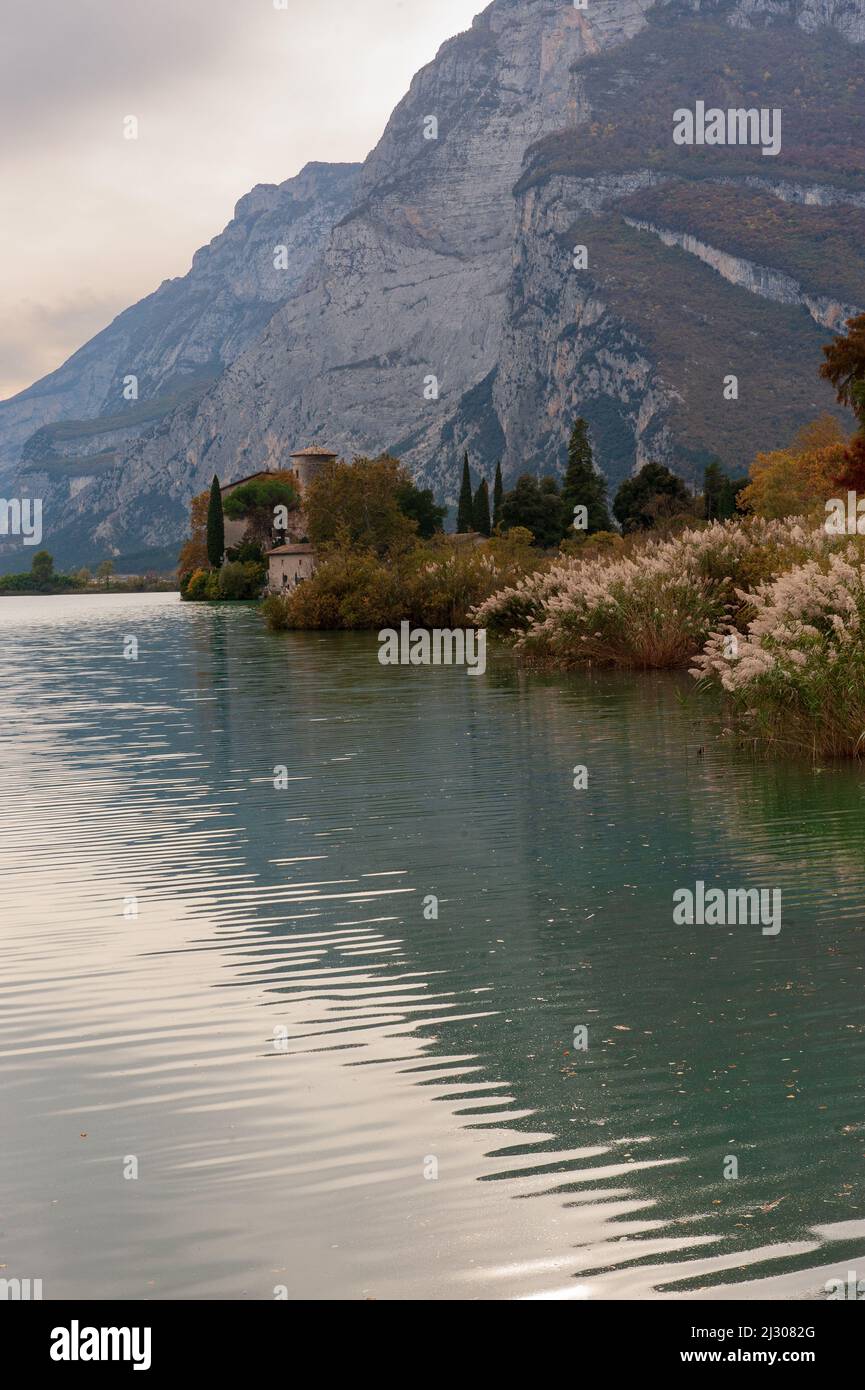 Lago Toblino con el castillo en autumnal disfraz. Es un pequeño lago alpino en la provincia de Trento (Trentino-Alto Adige) y ha sido declarado Biotope por sus cualidades naturalistas. Ubicación utilizada para la producción de películas. Italia Foto de stock