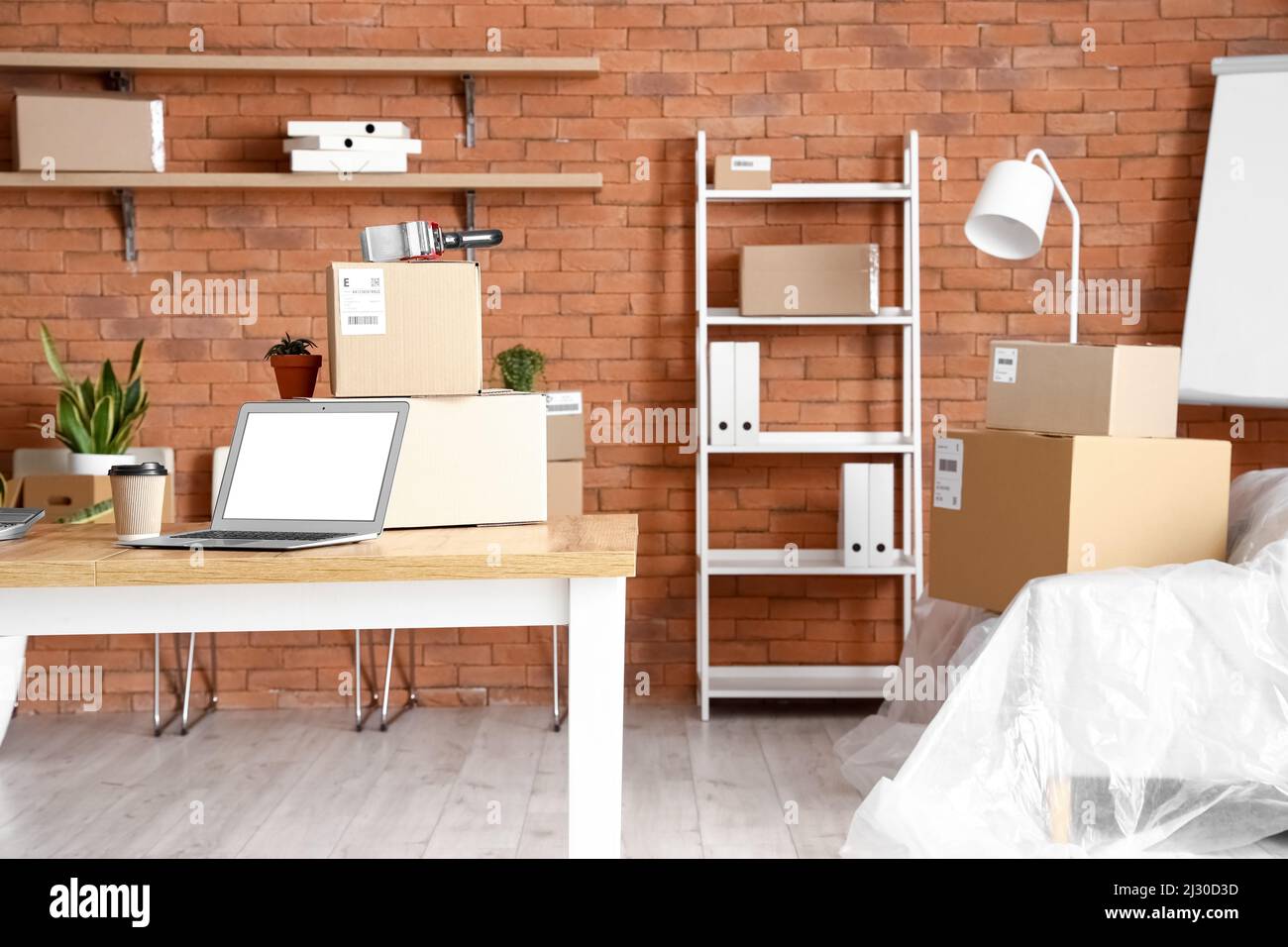 Cajas de cartón con pertenencias y muebles en el interior de la oficina en  el día de mudanza Fotografía de stock - Alamy