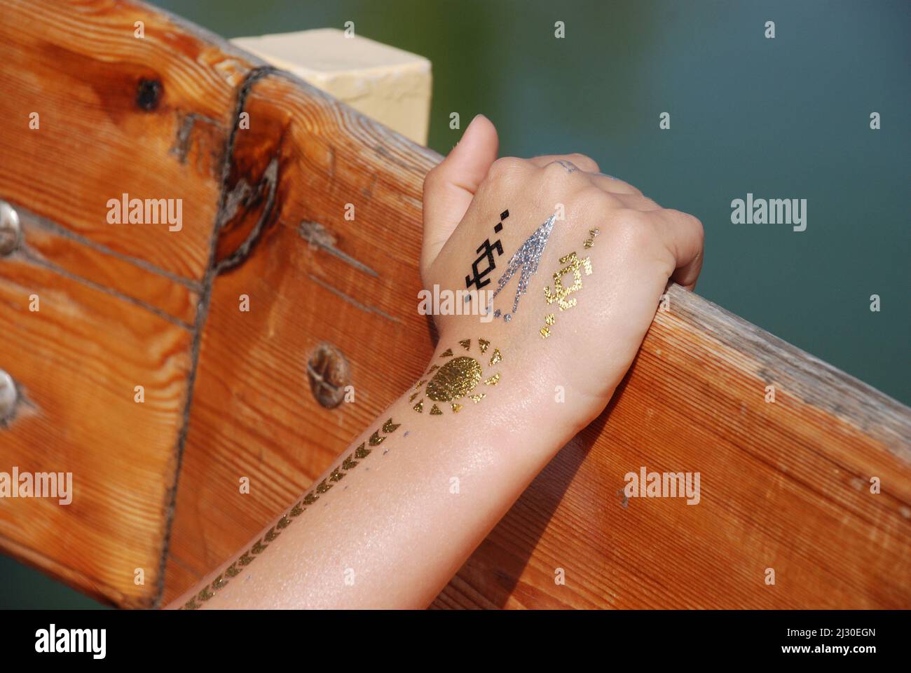 Tatuaje temporal dorado en la mano de un niño Foto de stock
