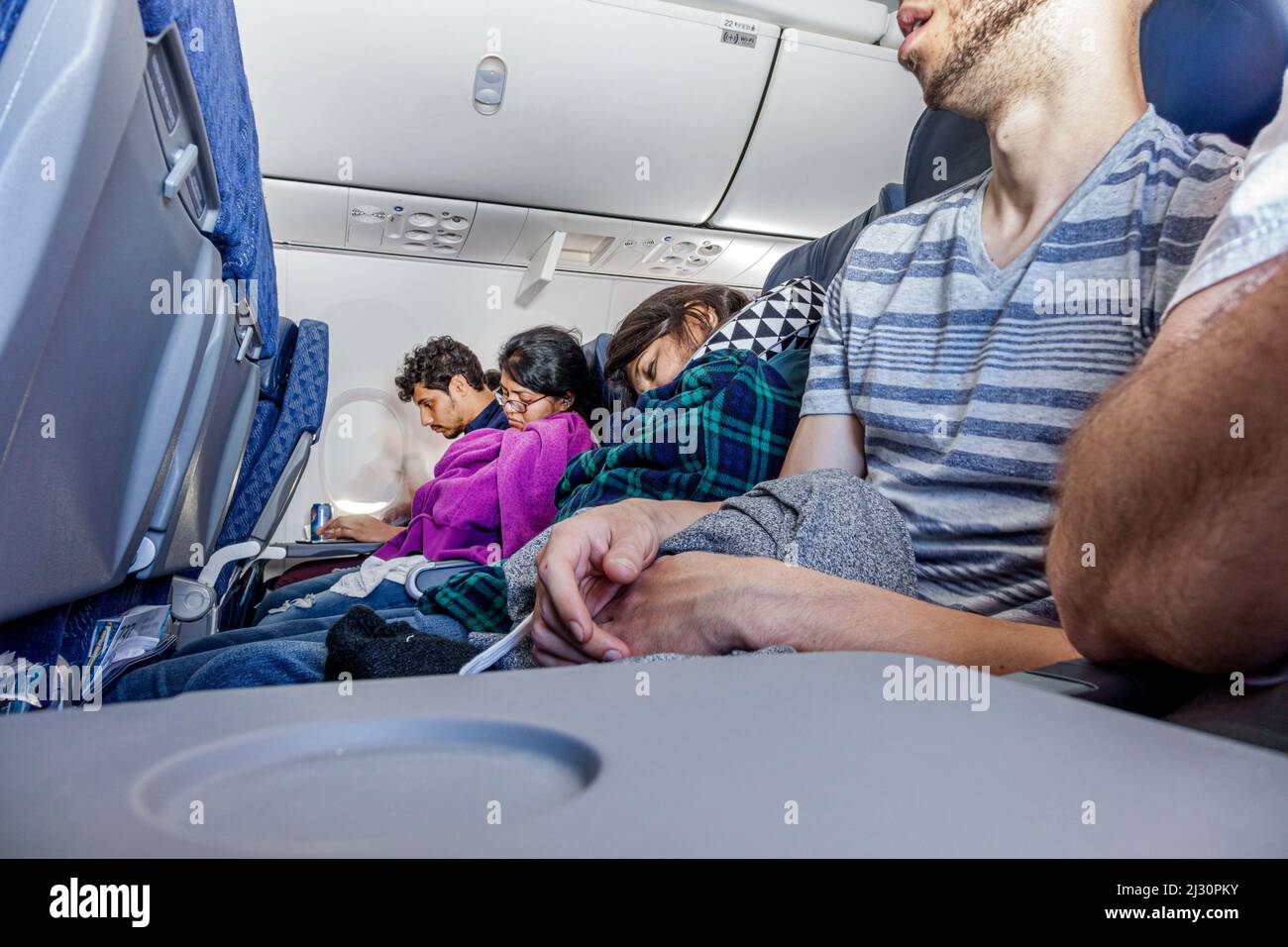 Miami Florida, American Airlines, vuelo de avión de pasajeros de avión de pasajeros de clase turista asientos fila hombres mujeres durmiendo napping a bordo Foto de stock
