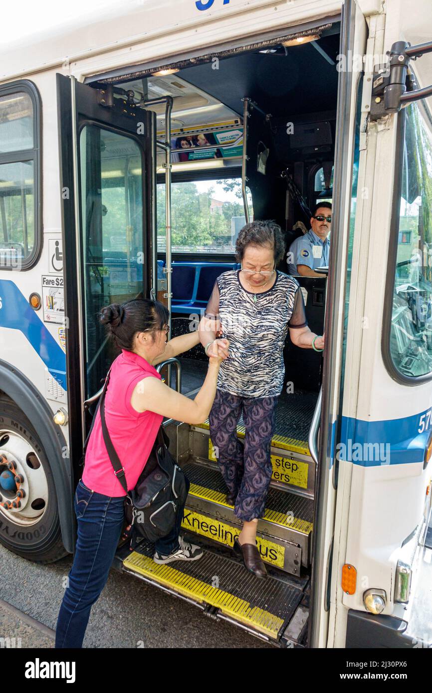 Ciudad de Nueva York, NY NYC, Bajo Manhattan Chinatown, MTA transporte público autobús, parada, hija adulta asiática ayudando a la madre ciudadana mayor a bajar Foto de stock