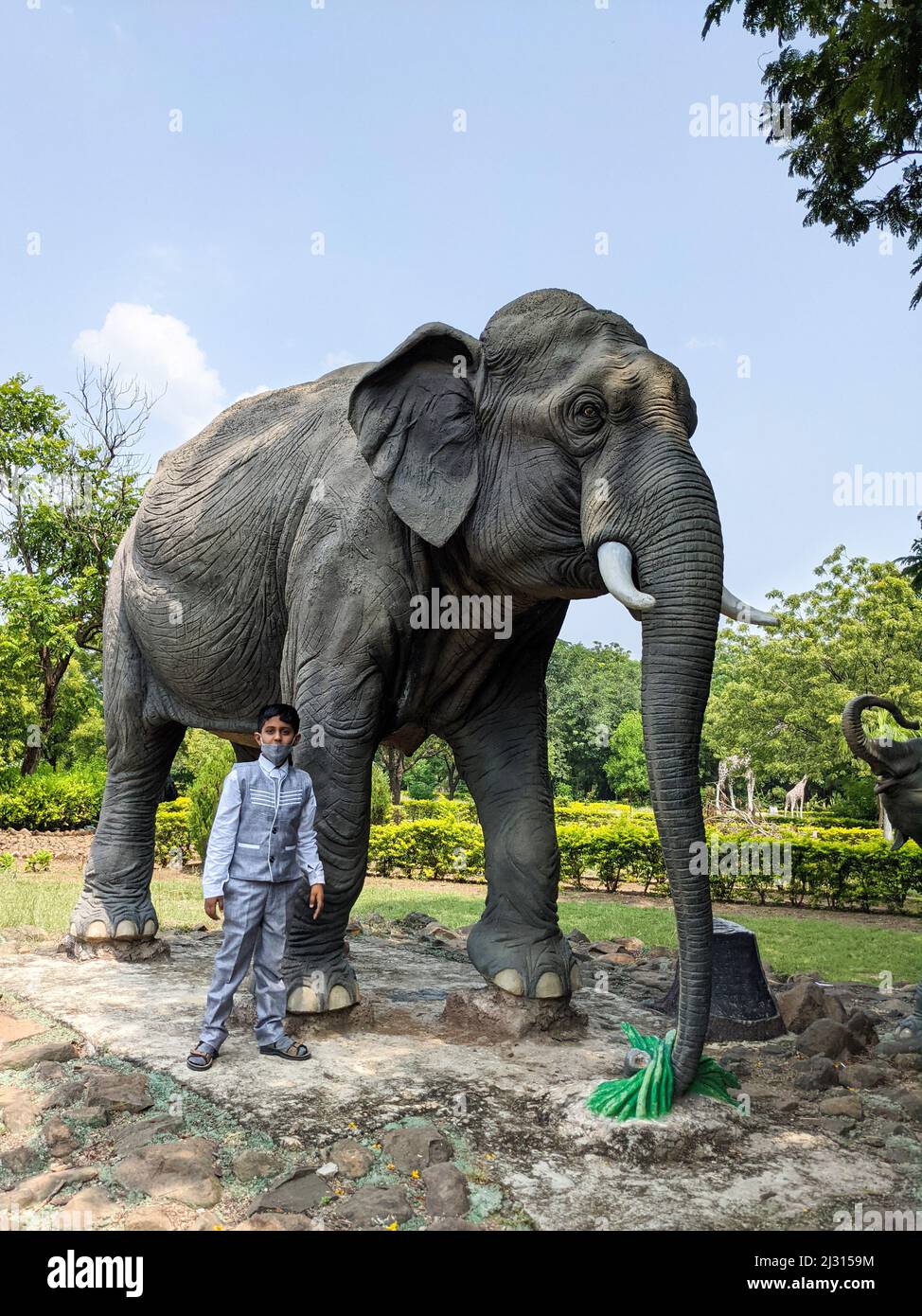 Hermosa vista de niño con gran escultura de elefante en el jardín: Kalaburagi, Karnataka, India-octubre de 14,2021 Foto de stock