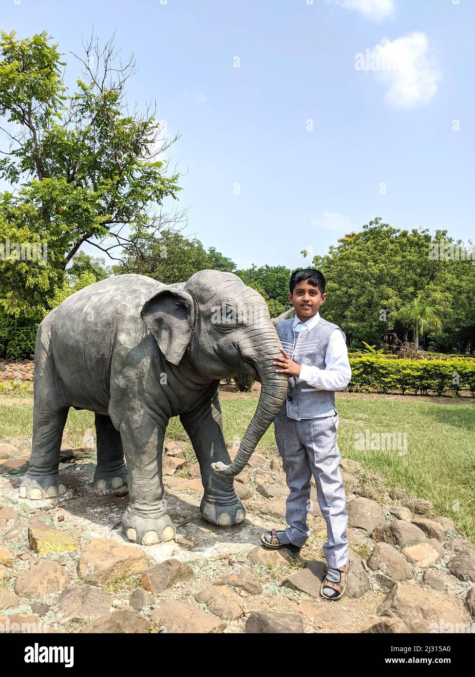 Hermosa vista de niño con pequeña escultura de elefante aislado en el jardín: Kalaburagi, Karnataka, India-octubre de 14,2021 Foto de stock
