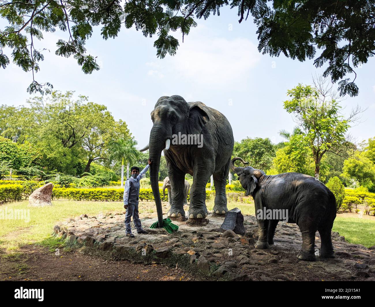 Vista del niño con esculturas de la familia Elefantes aisladas en el jardín: Kalaburagi, Karnataka, India-Octubre 14,2021 Foto de stock