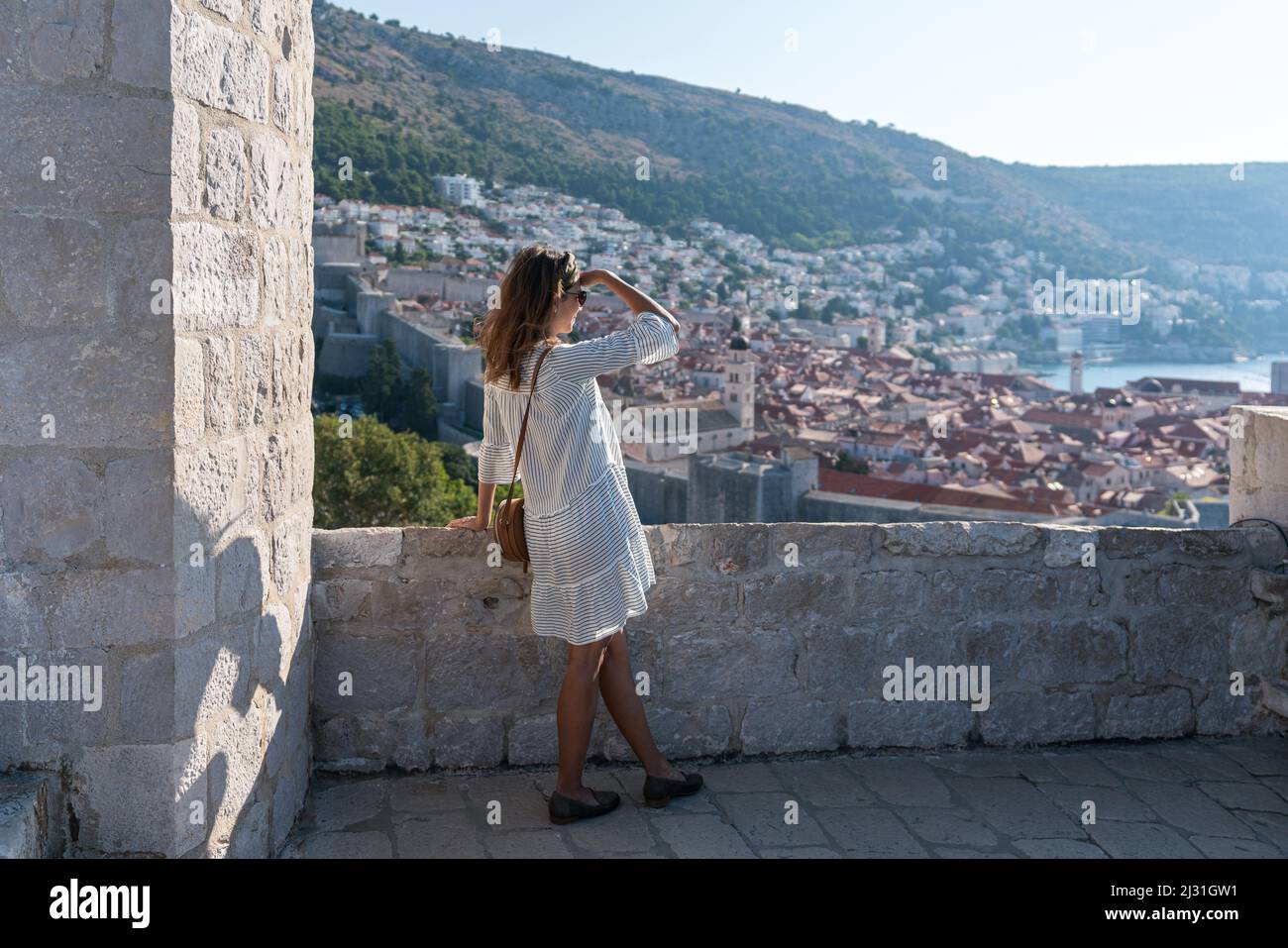 Mujer mira desde Fort Lovrenijac a la ciudad vieja de Dubrovnik, Dalmacia, Croacia. Foto de stock