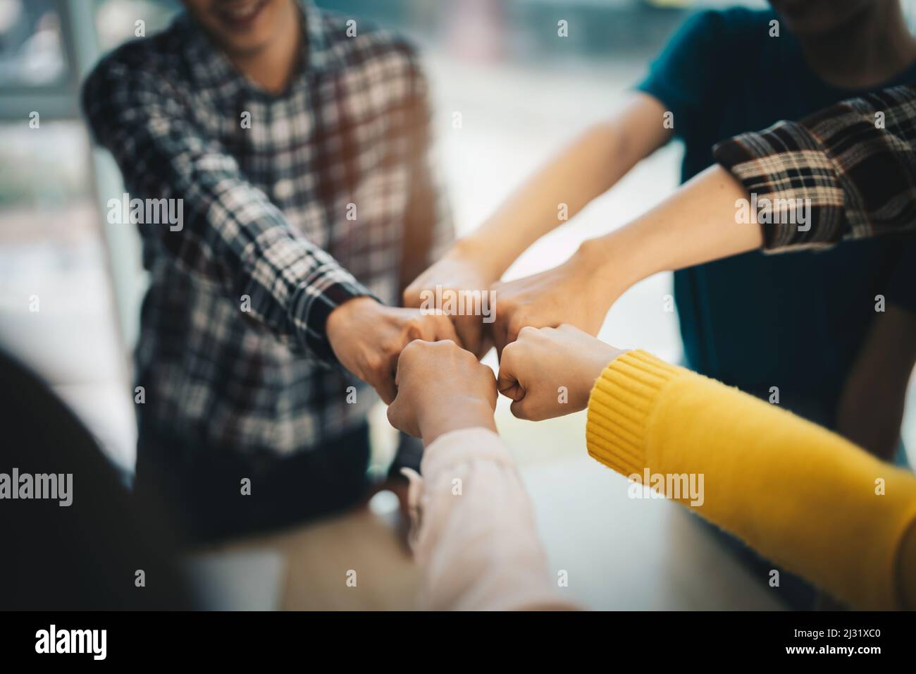 un grupo diverso de socios de negocios asiáticos se ha topetado en la oficina moderna. Trabajo en equipo de colaboración entre colegas, estudiante universitario, evento de felicitación, trabajo o. Foto de stock