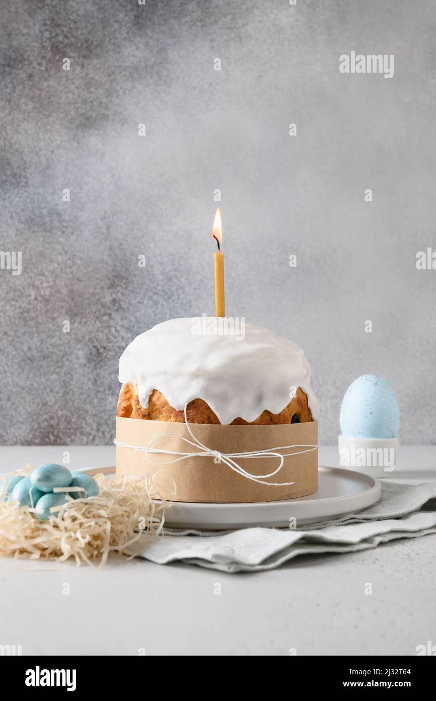 Tarjeta de felicitación de Pascua con vela de merengue decorada con el  tradicional kulich de Pascua y huevos con forma de caña de caramelo azul  sobre fondo gris. Vertica Fotografía de stock -