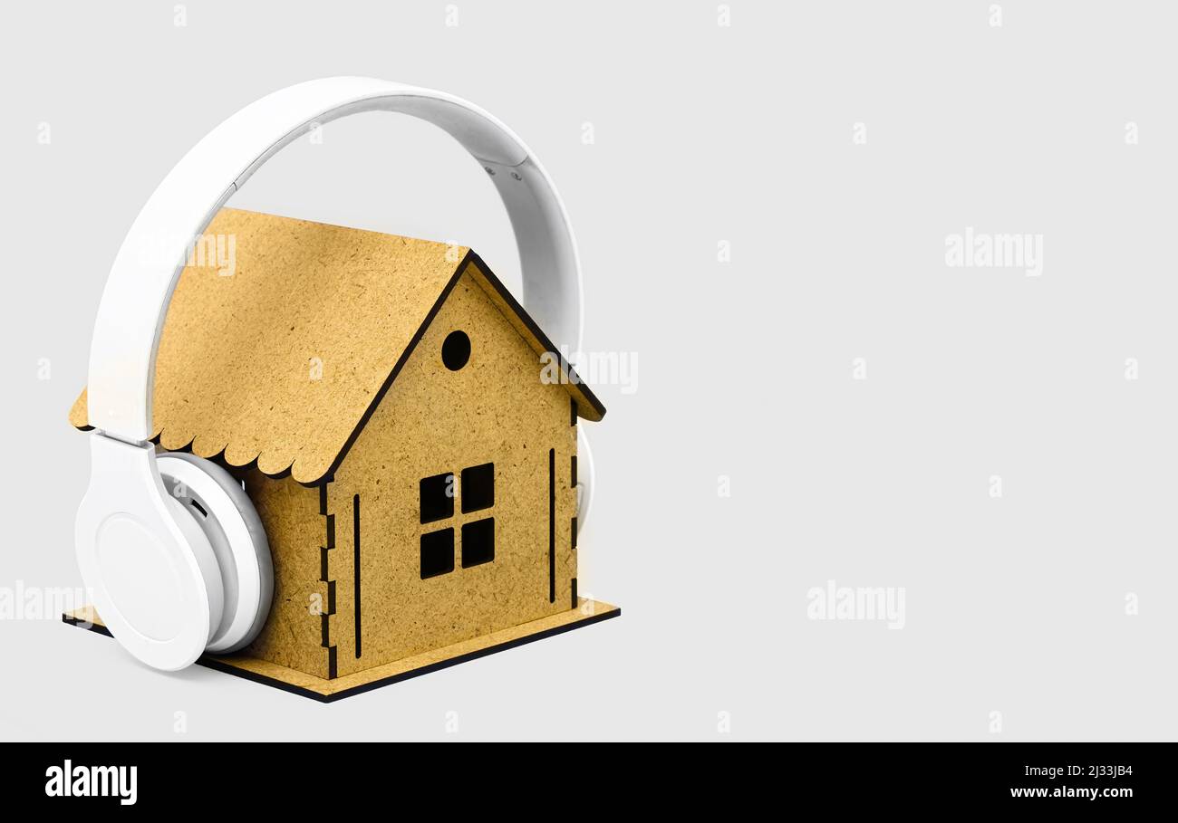 Auriculares inalámbricos blancos en un modelo de casa de madera en  miniatura aislado sobre fondo blanco. Concepto de aislamiento acústico y  ruido de la casa Fotografía de stock - Alamy