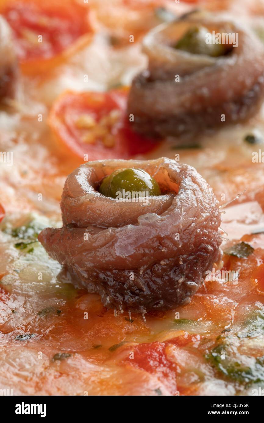 Rodó anchoa y alcaparras en una pizza italiana de cerca Foto de stock