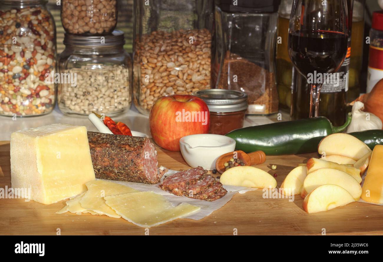 Salami de Peppercorn en bandeja con queso inglés e irlandés, manzanas en rodajas y especias en