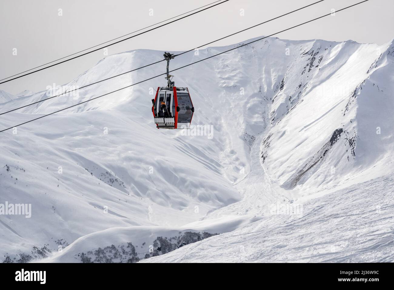 Góndola contra las montañas nevadas del Cáucaso, Gudauri Foto de stock