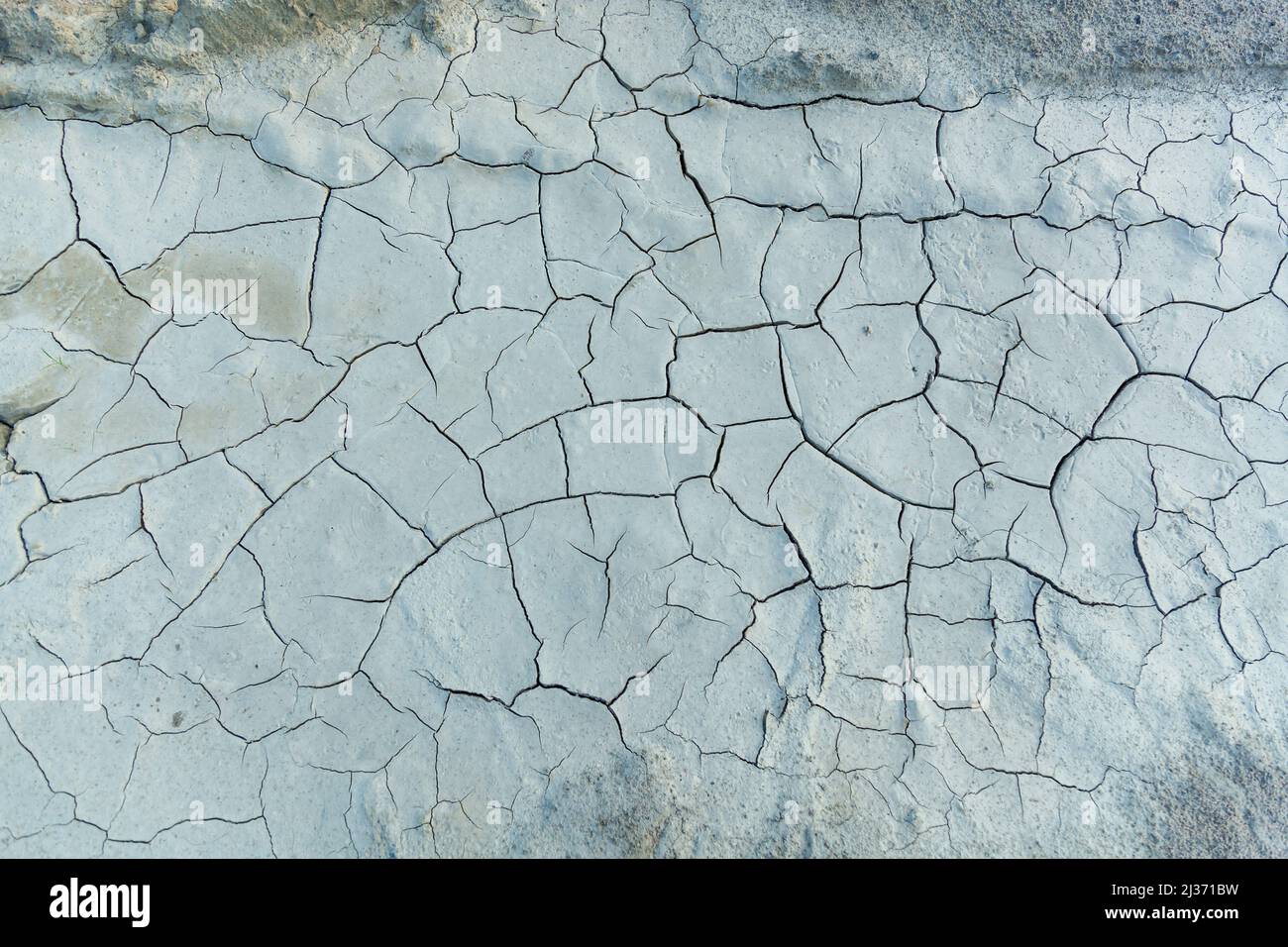 La tierra agrietada de la sequía, arcilla blanca con grietas. Textura y fondo para el diseño Foto de stock