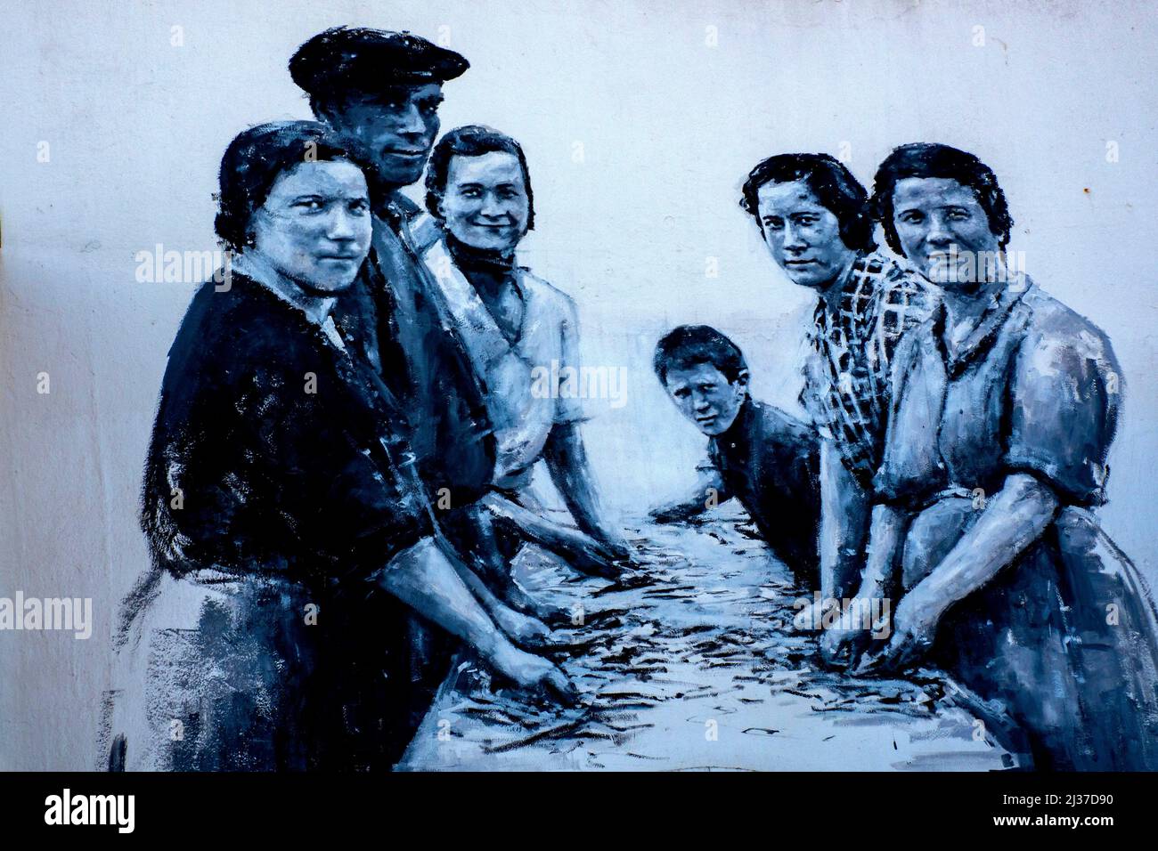 España-País Vasco-Guipúzcoa- ALIMENTOS: Pintura callejera que representa a la familia preparando peces para salados o enlatados, en Guetarria. Foto de stock